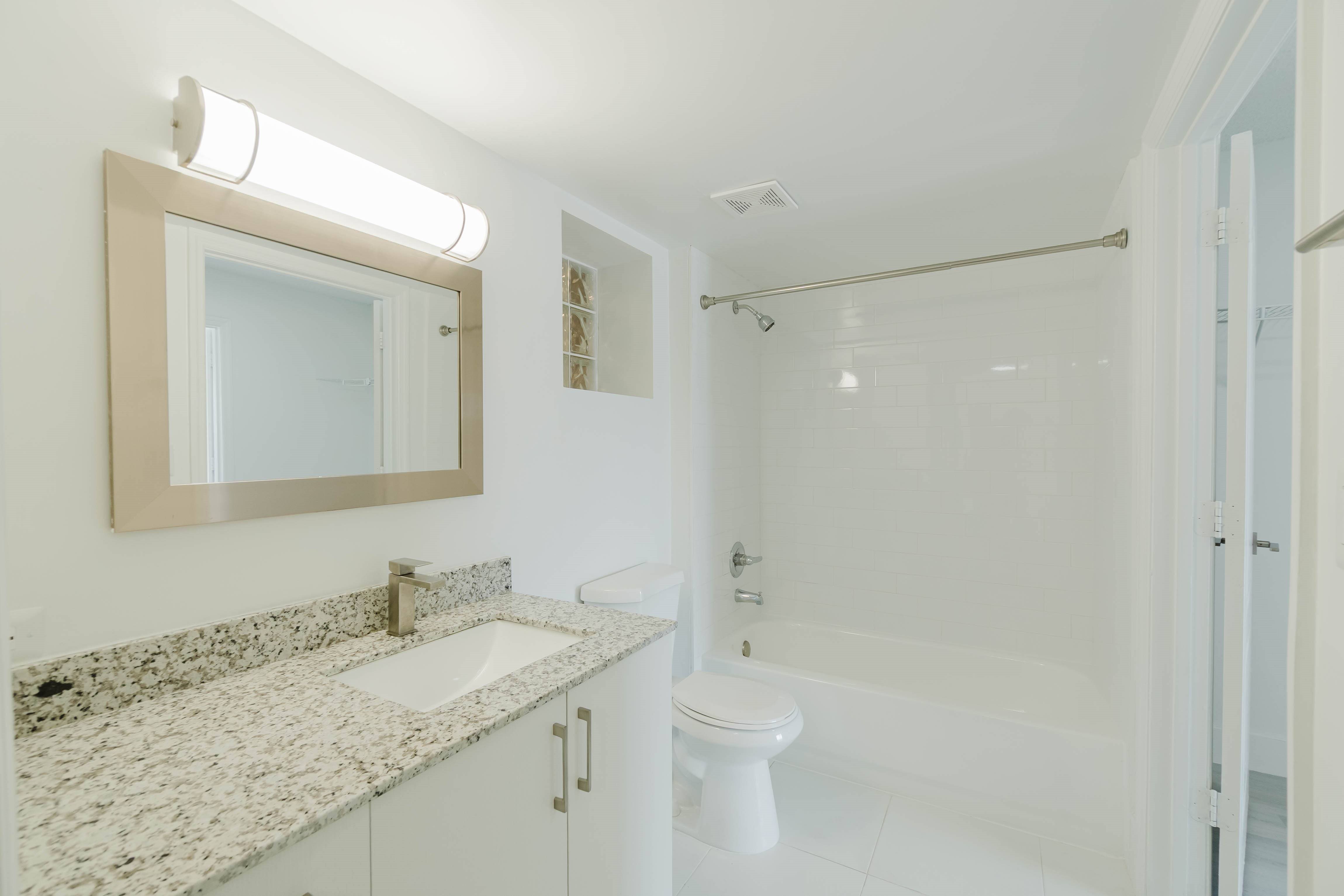 A bathroom with a sink, toilet, and shower.